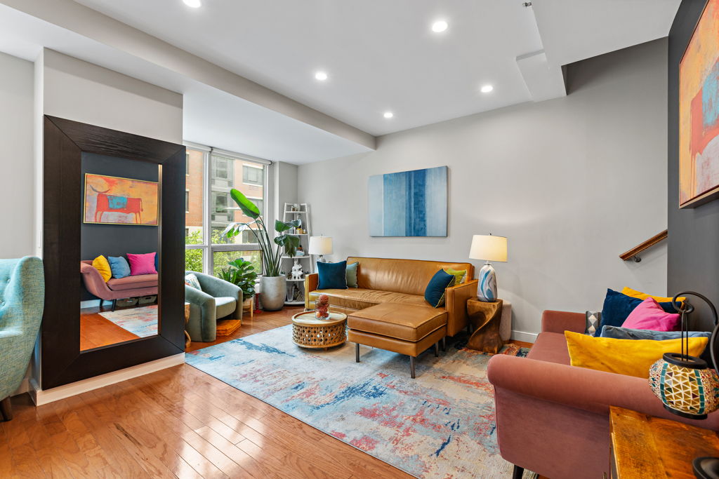 Living room with colorful seating and large windows at 1 Shore Lane residence 318 in Jersey City