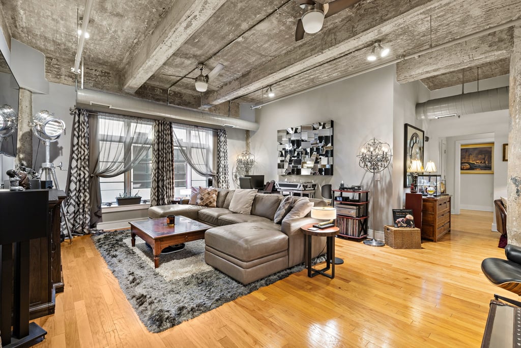 Loft living room with exposed concrete ceiling beams and wood floors at 140 Bay Street unit 4C in Jersey City