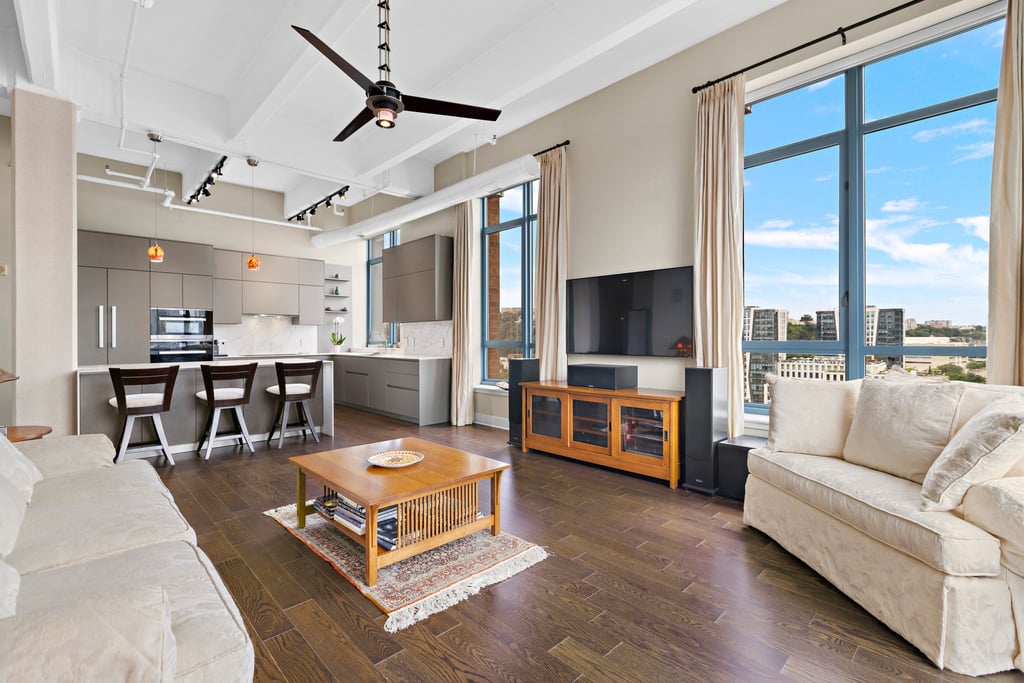 Open living room and kitchen with tall windows at Harborside Lofts, 1500 Garden Street residence 9F