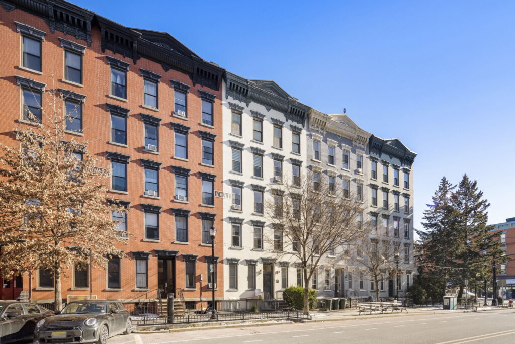 Rowhouses with brick and light-colored facades along Washington Street near 11th Street in Hoboken